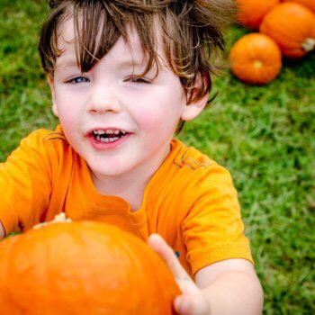 child holding pumpkin