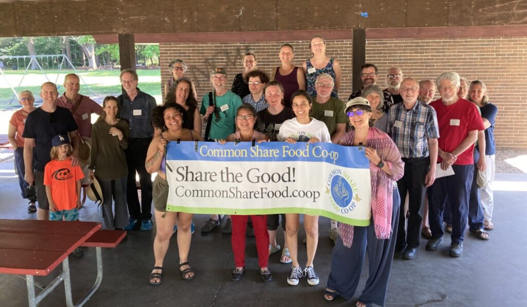 Attendees of the 2024 annual meeting holding a Common Share banner.